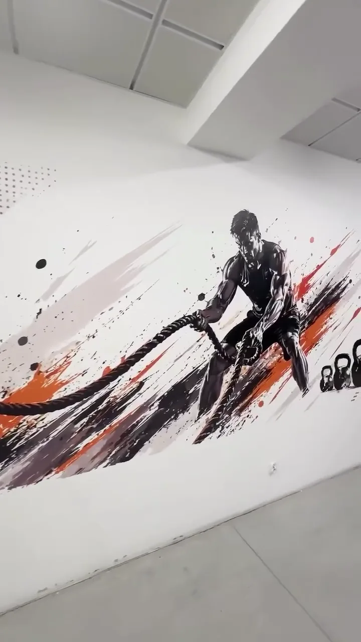 Spor salonu duvarında sporcu figürlü baskı uygulama örneği